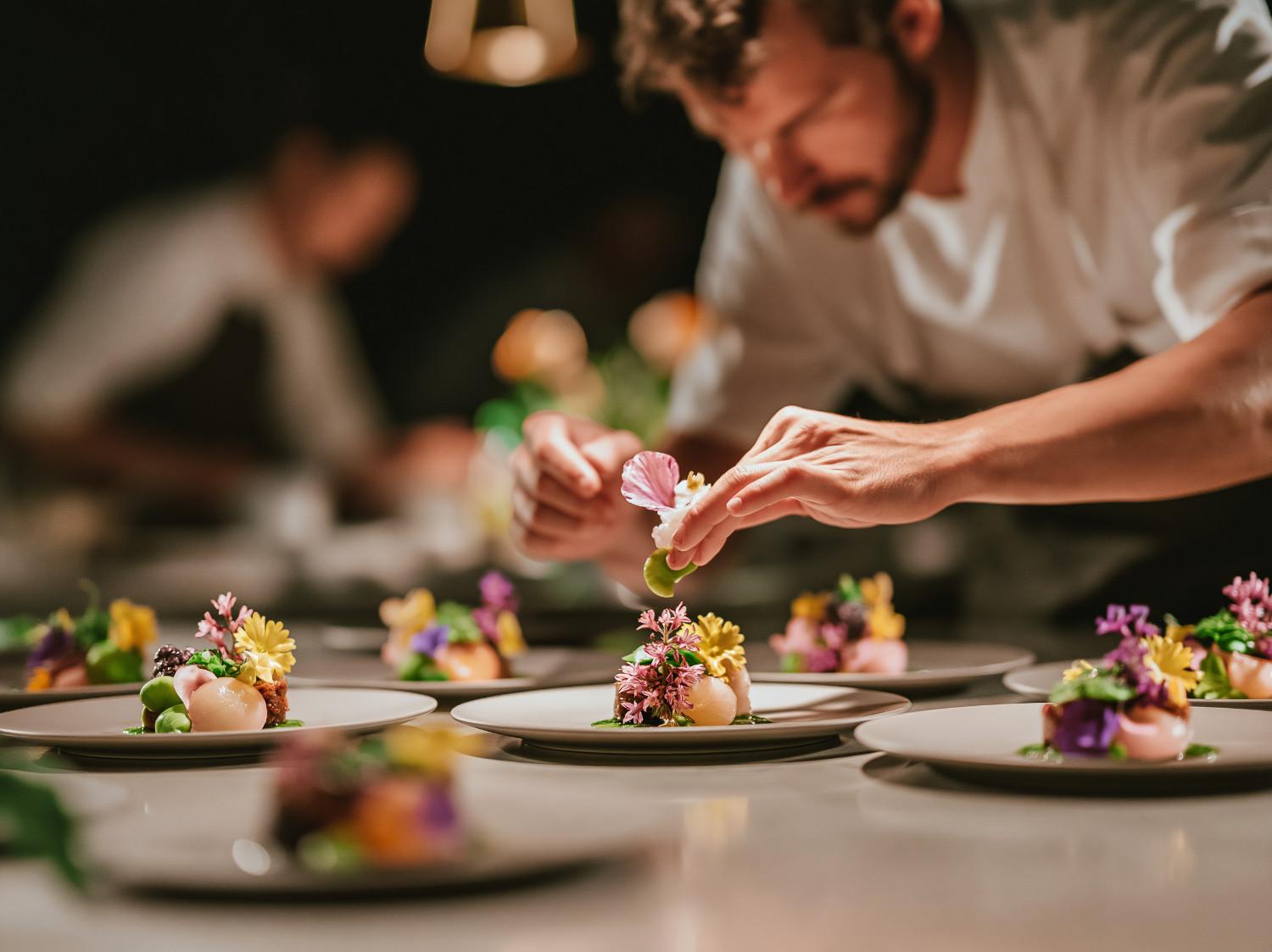 A chef plating a delicate tasting-menu course